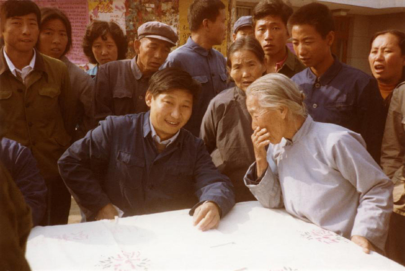 1983年，時(shí)任河北正定縣委書記的習(xí)近平（前排居中），臨時(shí)在大街上擺桌子聽取老百姓意見。